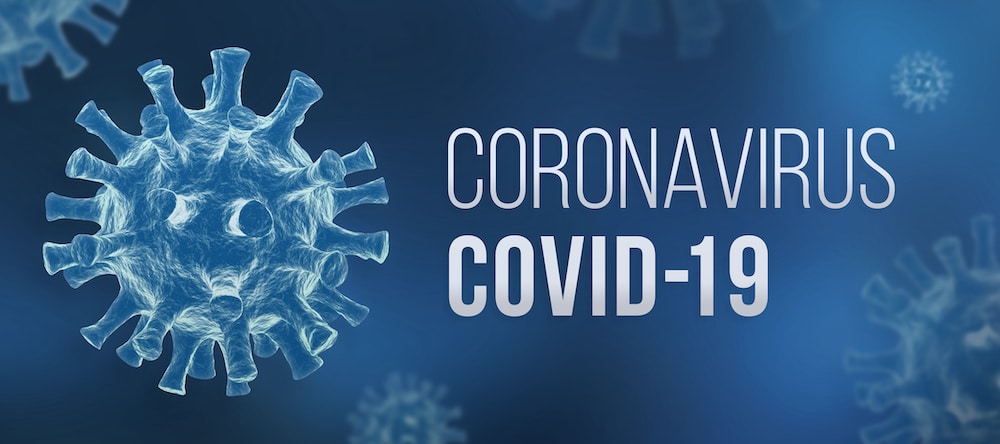 Illustration of the COVID-19 virus on a blue background with the text "CORONAVIRUS COVID-19" displayed prominently to the right. The virus is depicted as a spherical object with spike-like protrusions.